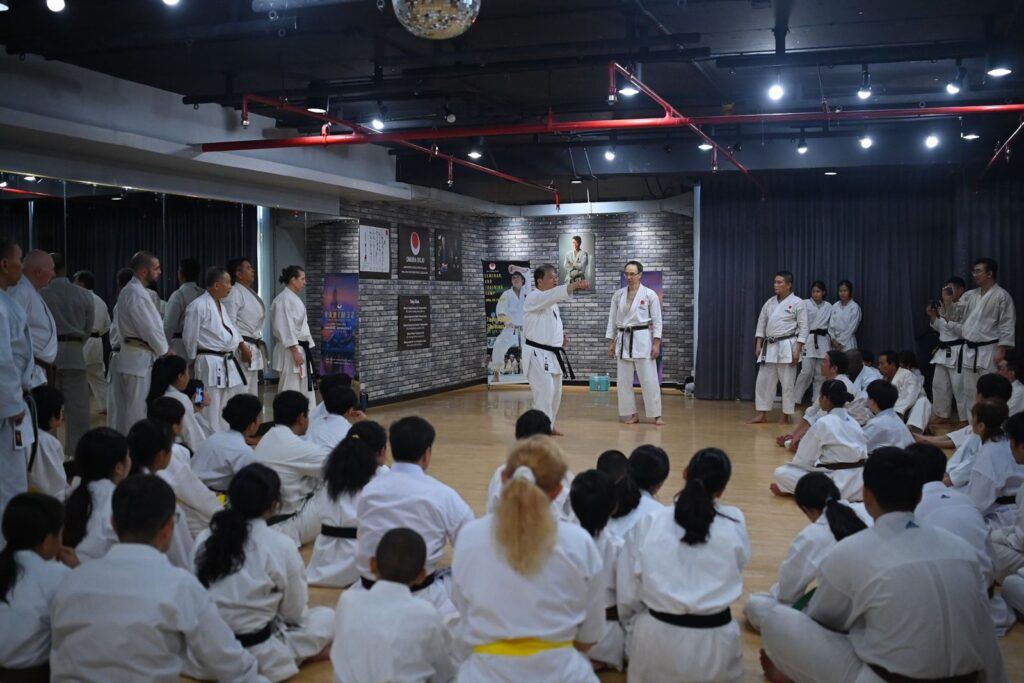 Participants seated on the floor listening to instructors at the 2025 seminar